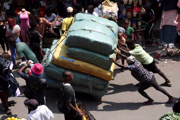 People push a cargo cart through Balogun Market in the Marina business district of Lagos, Nigeria, December 2, 2025. REUTERS/Sodiq Adelakun/File Photo (Reuters)